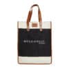 A stylish tote bag with brown leather handles and trim, featuring a black canvas central section. The text 