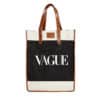 A beige and black tote bag with brown leather handles and accents. The word 