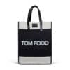 A two-toned tote bag with black central panels and cream-colored top and bottom edges. The bag features black handles and the words 