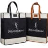 Two vertically standing Yves Saint Croissant bags are shown. One boasts black handles with black leather accents and a black body, while the other features brown handles, brown leather accents, and a black body. Both bags are elegantly distinguished by beige at the top and bottom.