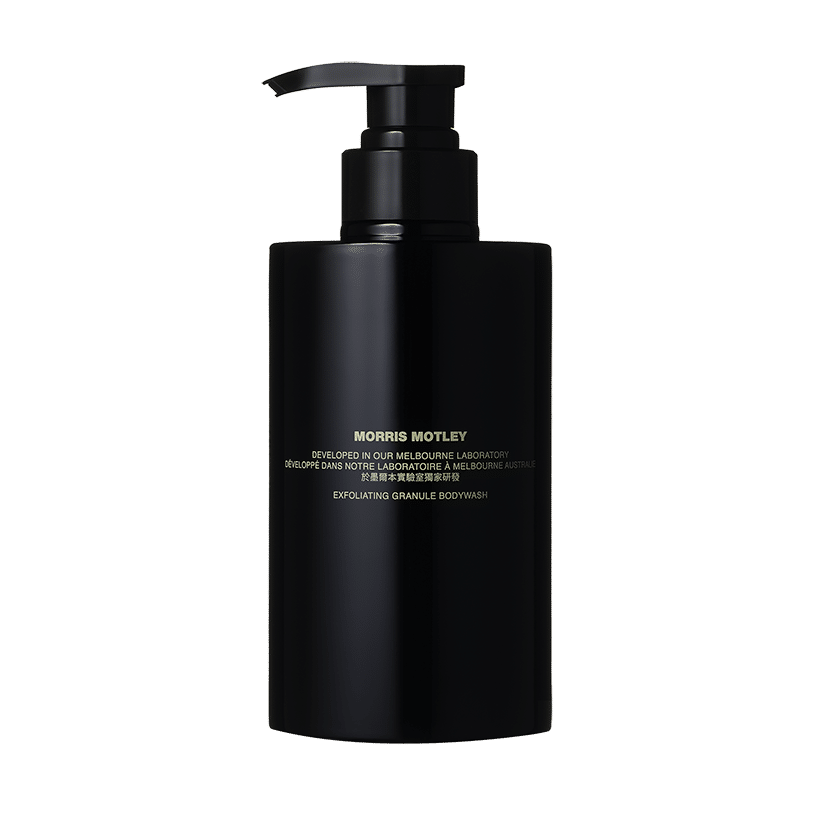 A sleek black bottle with a pump dispenser labeled “Exfoliating Granule Body Wash, 500 ml.” The text on the bottle is in white and yellow. The design is minimalist and modern.
